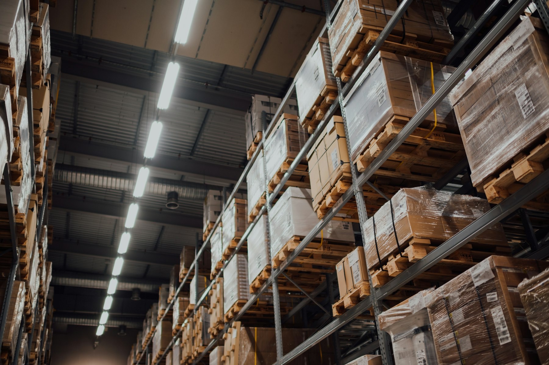 Shrink-wrapped pallets stored on steel racking under warehouse lighting