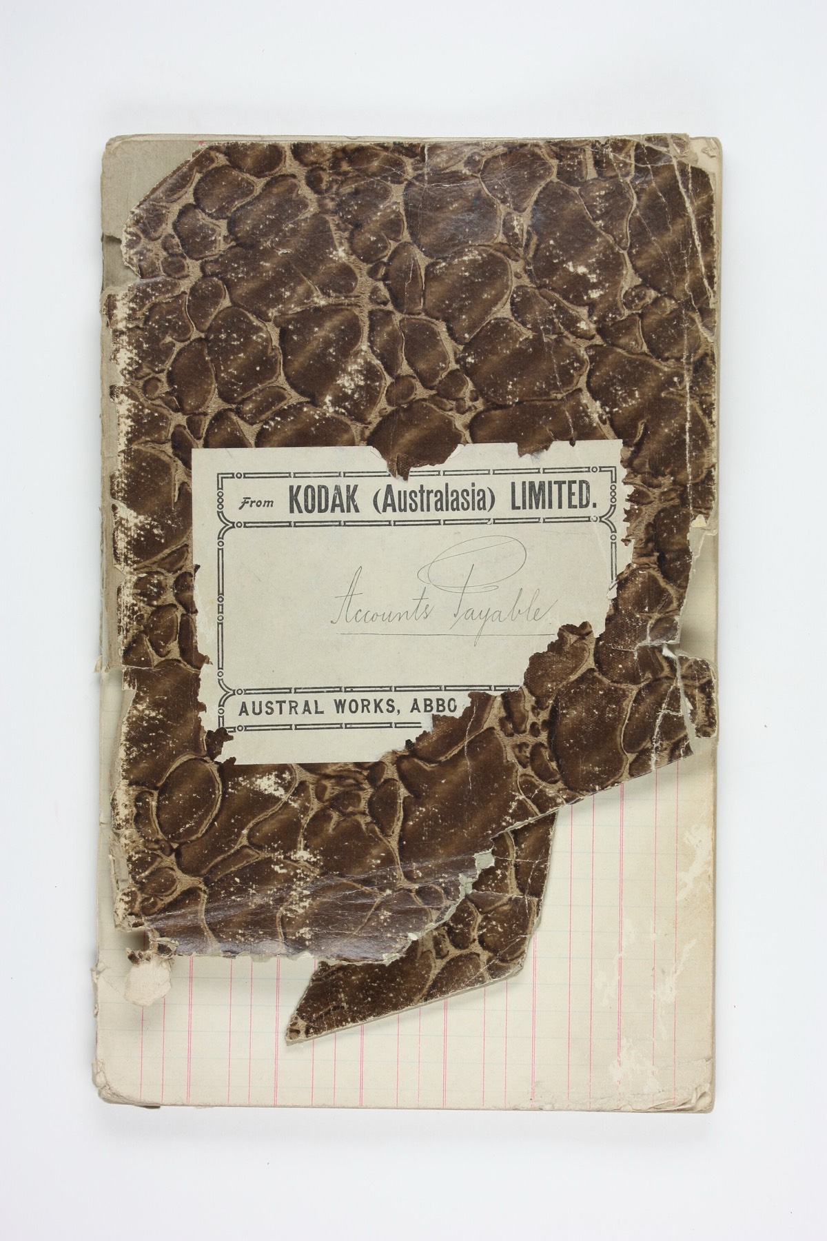 A battered accounts payable ledger, its marbled cover torn back to the ruled pages beneath.